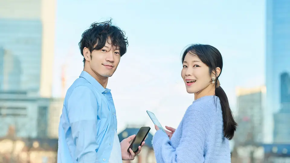 スマートフォンを手に笑顔の男女