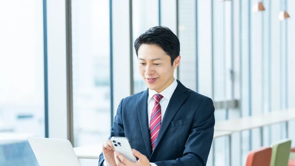 オフィスでスマホを見るビジネスマン