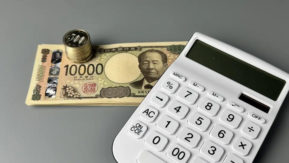 小銭とお札と電卓の家計管理のイメージ