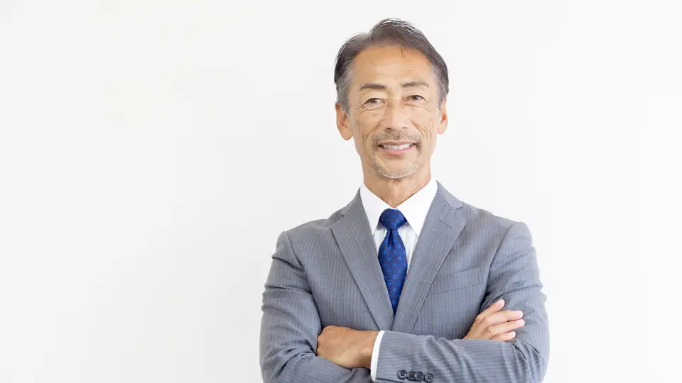 腕組みをするグレイヘアのビジネスマン