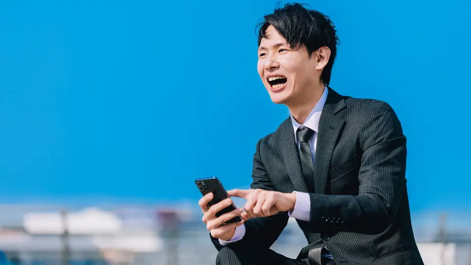 屋外でスマホを使う日本人男性ビジネスマン