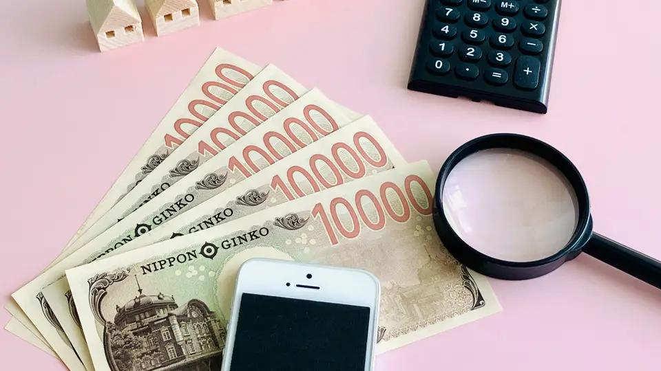 住宅とお金、スマホ、ルーペ、電卓