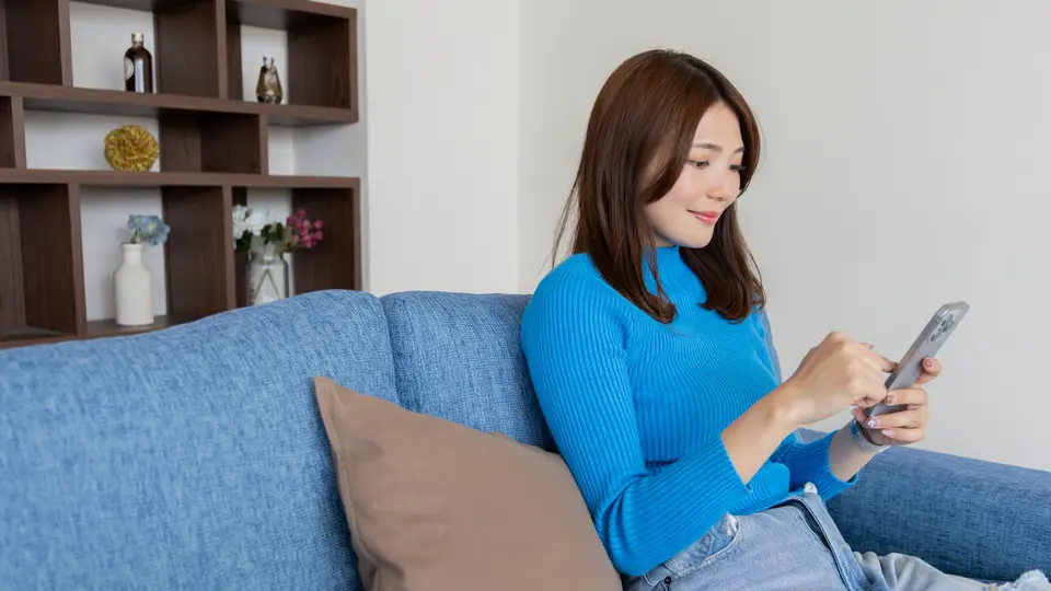 スマートフォンを見るリラックスした女性