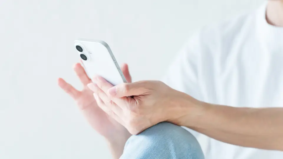 スマートフォンを使う若い男性の手元