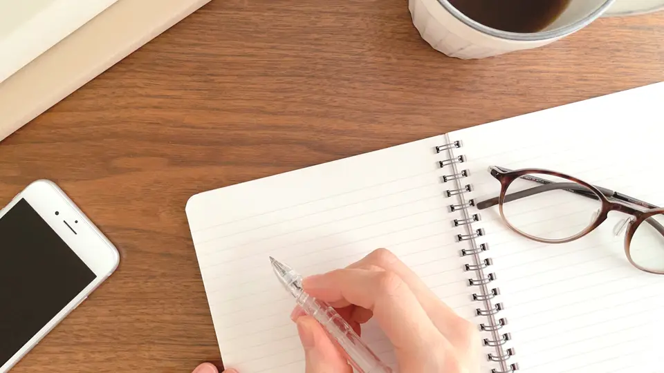 ノートに字を書く女性の手 勉強イメージ