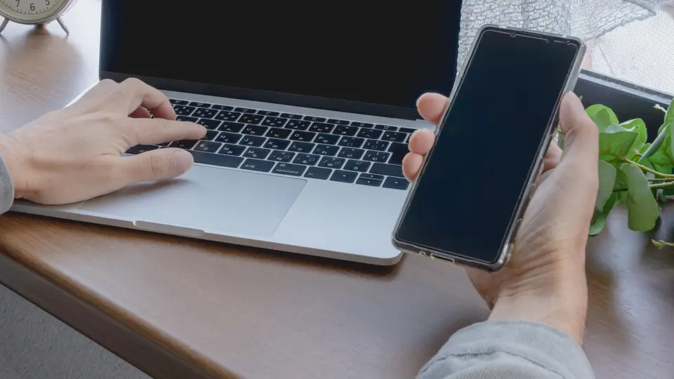 スマホとパソコンを操作する手元