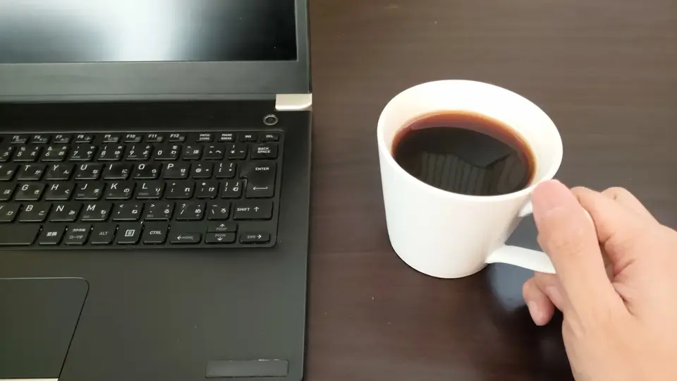 ノートPCとコーヒーで休憩する手元