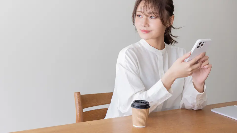 カフェでスマートフォンを使う女性