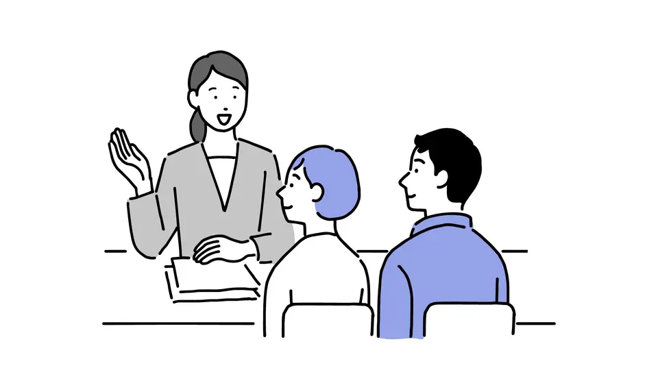 スーツの女性と若夫婦が机を挟んで相談する