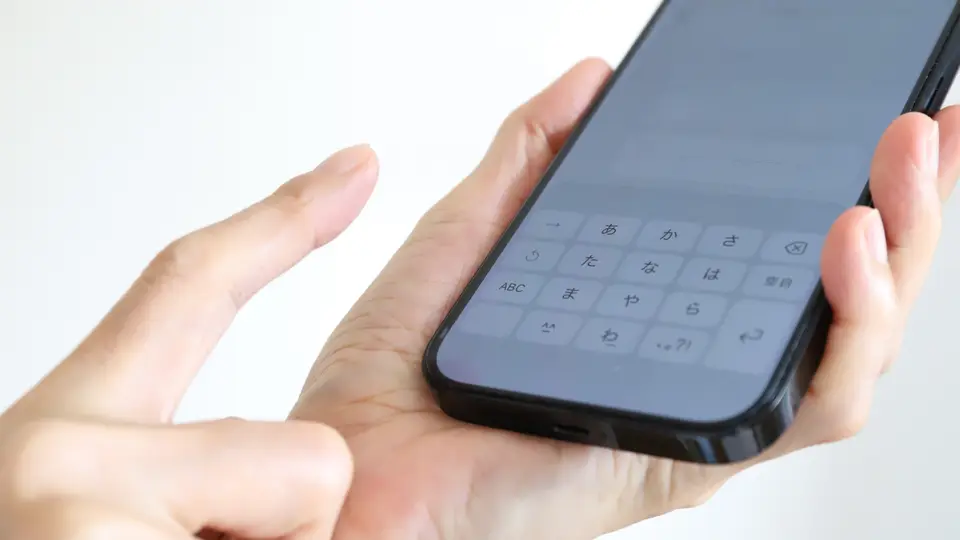 スマートフォンで文字入力をする手元