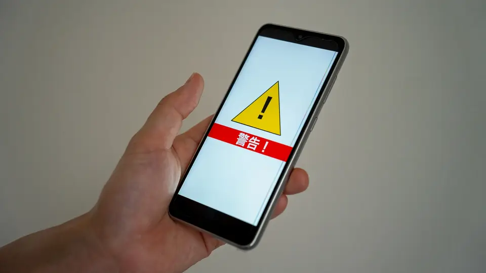 スマホ画面と警告マーク