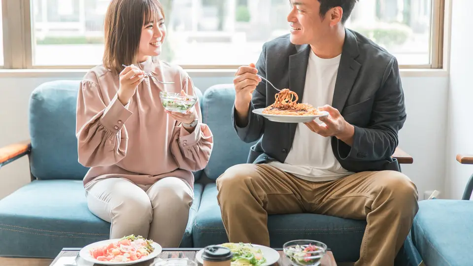 カフェ・レストランでランチを食べる男女