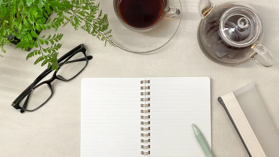 コーヒーとノートと眼鏡デスク俯瞰