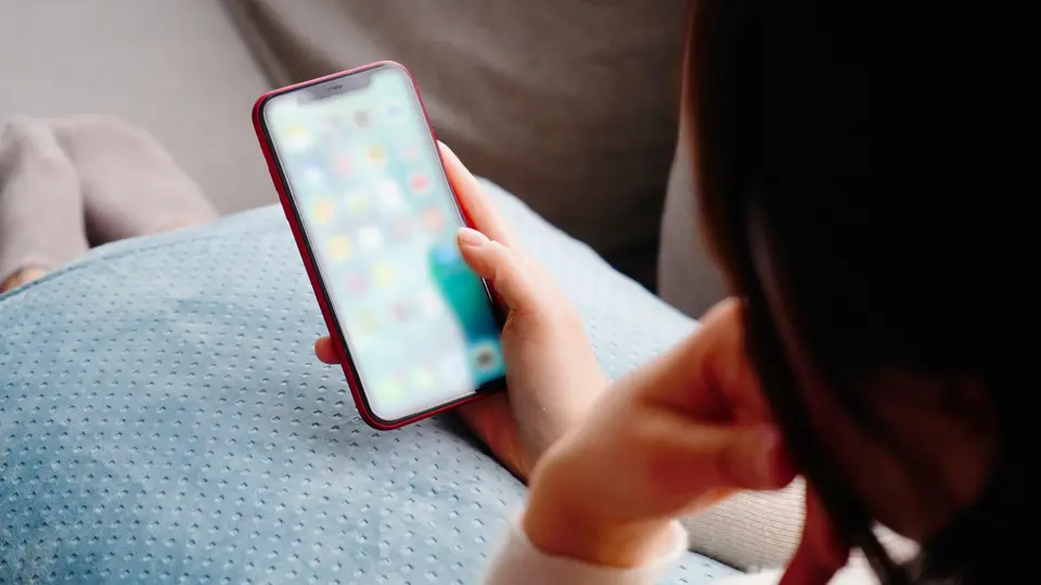 スマホを見て感がる女性の後ろ姿