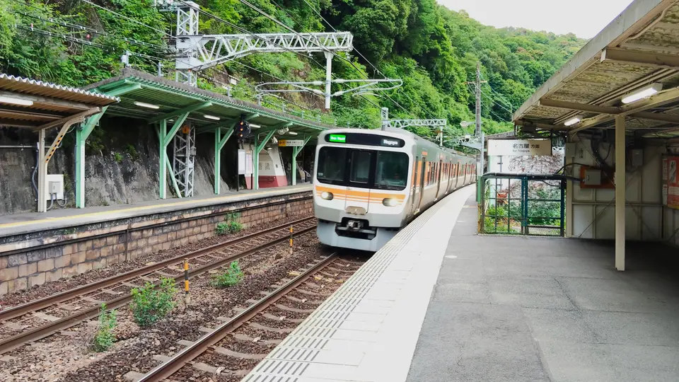 新緑の山あいを走るローカル線の電車