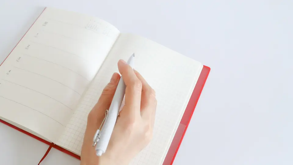 手帳に書き込む手元