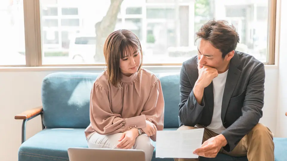 書類を見てカフェでミーティングする男女