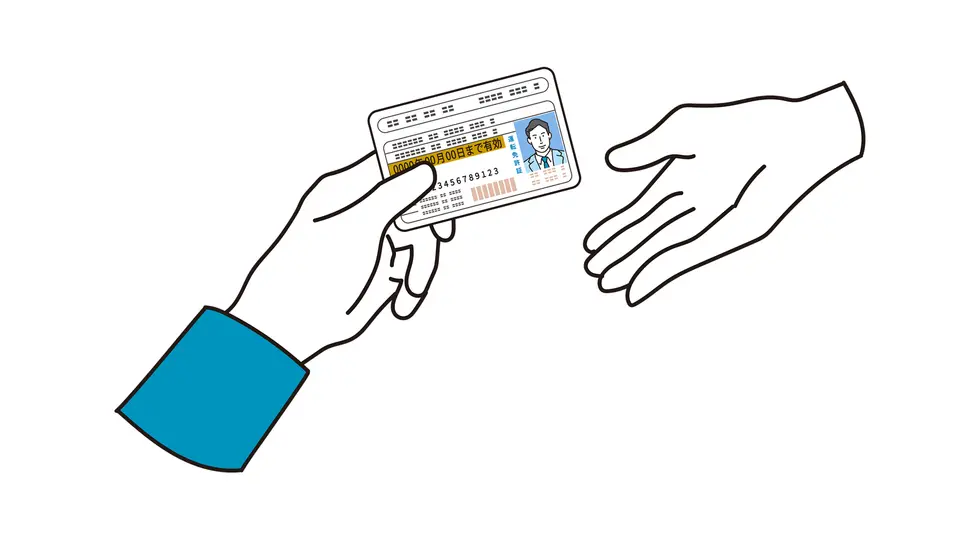 手続きで免許証を渡す手元
