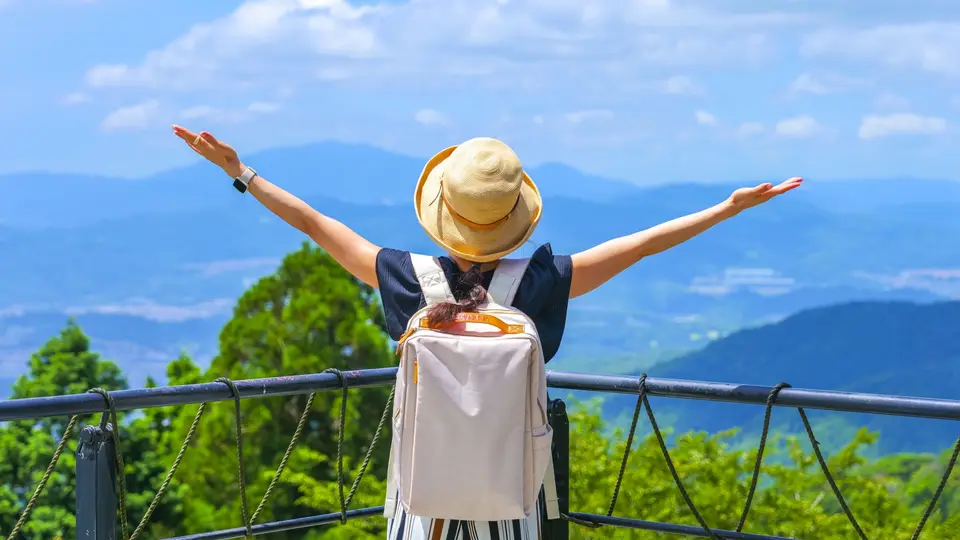 大空に向かって両手を広げる女性